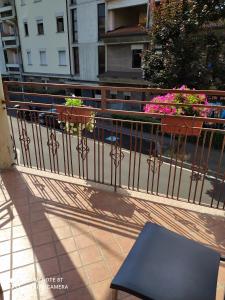 un balcón con una valla, una mesa y flores en CASA VACANZE LUNA, en Seriate