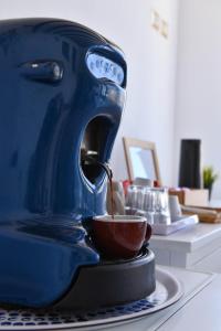 a blue coffee maker pouring coffee into a cup at Mamamia #Lipari in Lipari +27 photos