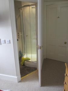 a bathroom with a shower with a glass door at Strome Lodge in Inverness