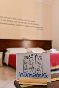 un cartello su un tavolo in una stanza con un letto di Mamamia Lipari a Città di Lipari