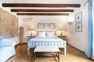 1 dormitorio con cama blanca y sofá en Finca Ca'n Quatre, en Sóller