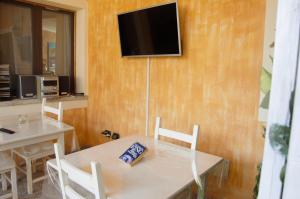 a dining room with a table and a television on a wall at Hotel Sa Cralla Villasimius in Villasimius