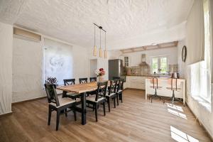 a dining room and kitchen with a table and chairs at Villa Pepina in Risika