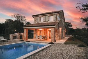 a house with a swimming pool in front of a house at Villa Pepina in Risika