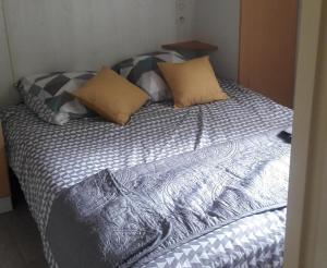 una cama con almohadas en una habitación en Chalet les Hameaux du Perrier, en Lissac-sur-Couze