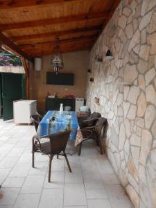 a stone wall with a table and chairs on a patio at Sveti Stefan- Apartment Dora in Sveti Stefan