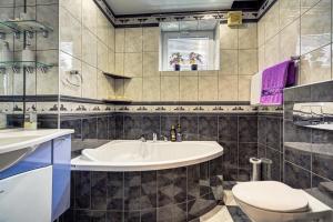 a bathroom with a tub and a toilet and a sink at APARTAMENT KWIATOWY Krynica Zdrój in Krynica Zdrój