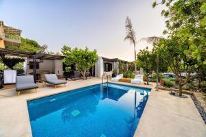 una piscina con 2 sillas y una casa en HALO Ligaria Suite 100m next to the beach with private pool en Lygaria