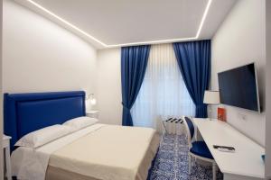 Habitación de hotel con cama y TV en Palazzo Langellotto, en Pompeya