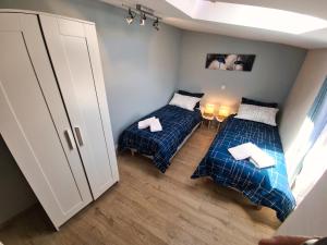two beds in a small room with a cabinet at Le Micocoulier in Montesquieu