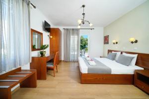 1 dormitorio con cama, mesa y escritorio en Antigone Hotel, en Limenas