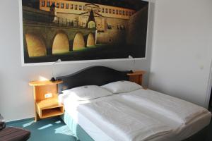 a bedroom with a bed with a picture on the wall at H+ Hotel Erfurt in Erfurt +34 photos
