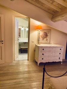 een slaapkamer met een witte dressoir en een spiegel bij la locanda di anita in Cetona