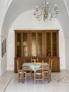 a dining room with a table and a chandelier at Casa di Rosaria - Due appartamenti nel centro storico con giardino sul terrazzo in Depressa +23 photos