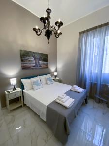 sypialnia z dużym łóżkiem i żyrandolem w obiekcie La Fitolacca B&B w mieście Lecce