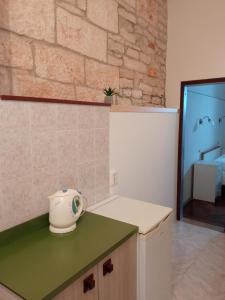 La cuisine est équipée d'un comptoir vert et d'un réfrigérateur. dans l'établissement Rooms Zela 1, à Korčula
