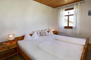 een slaapkamer met een groot wit bed en een raam bij Ferienwohnungen Haus Willburger in Tettnang