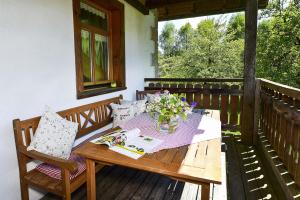 een houten tafel met een vaas met bloemen op een veranda bij Ferienwohnungen Haus Willburger in Tettnang