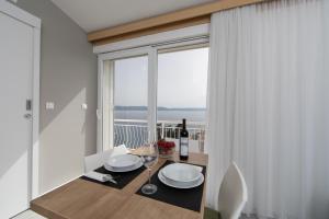 a dining room with a table and a large window at Apartments Klaricic in Živogošće