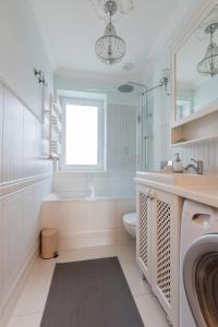 a white bathroom with a sink and a toilet at Elegant near Old Town - free parking in Gdańsk