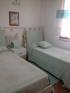 une chambre avec deux lits et une lampe et une fenêtre dans l'établissement Villetta Meravigliosa, à Rena Majore