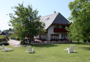 tres sillas sentadas en el césped frente a una casa en Villa Galagonya I. II., en Balatongyörök