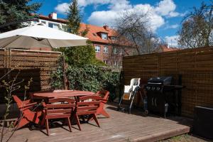 a patio with a table and an umbrella and a grill at Elegant near Old Town - free parking in Gdańsk