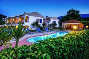 a villa with a swimming pool in front of a house at Antigone Thassos Hotel in Limenas