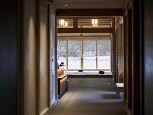 a hallway with a view of a room with a window at Hakujukan in Eiheiji