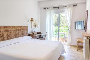 - une chambre avec un lit et une porte coulissante en verre dans l'établissement Hotel Noguera Mar, à Dénia