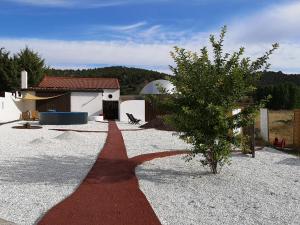 a red pathway leading to a house with a tree at Burbuja AntiSaturno - Glamping Alto Tajo in Ablanque