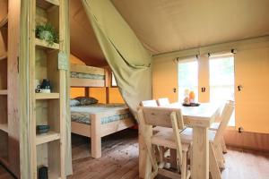 a room with a table and a bed in a tent at TENTE SAFARI Lodge FERME CARRIQUE in Tardets-Sorholus