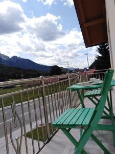 a green table and chair on a balcony with a view at Apartma Viktorija in Kranjska Gora