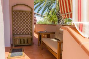 a balcony with a bench and a table at Casa vacanza Sa Ferula in Flumini di Quartu