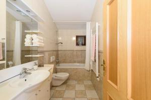 Un baño con lavabo, inodoro y bañera. en Apartments Kaskada, en Marina 80 fotos más
