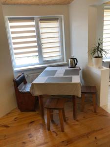 a table and chairs in a room with two windows at Апартаменты в 5 минутах от моря, пляж Черноморка, Одесса in Odesa