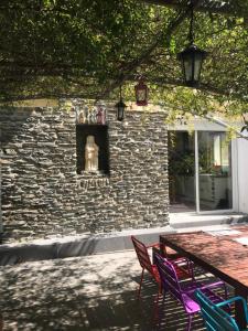 une table et des chaises devant un bâtiment en pierre dans l'établissement Grande maison catalane entre mer et montagne, à Reynès