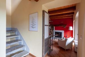 un soggiorno con scale e una parete rossa di Casa Regalino a Oggebio