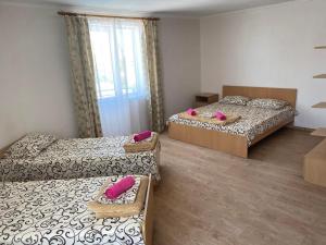 a room with three beds with pink pillows on them at Aquamarin in Zatoka