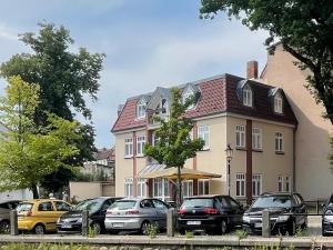 un grupo de autos estacionados frente a una casa en Kutscher's Ostsee FeWo - kostenlos Parken, en Wismar