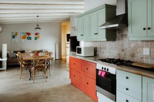 a kitchen with a table and a dining room at Phoenix 1 in Paternoster