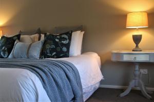 a bedroom with a bed and a lamp on a table at The Country Escape in Fernhill