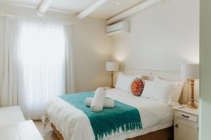 a bedroom with a large white bed with a green blanket at Phoenix 1 in Paternoster