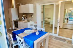 a kitchen with a table with a blue table cloth at VILLA MARE BLUE SR Nuovissima Villa 150m dal mare adatta a bambini in Terrauzza