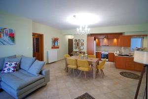 a living room with a couch and a table and a kitchen at KYPARISSIA LUXURY HOME in Kyparissia
