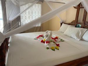 a bedroom with a bed with flowers on it at Visitor's Inn in Jambiani