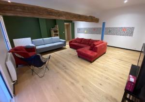 salon z czerwonymi kanapami i niebieską kanapą w obiekcie Bed&Bloc Climber Guesthouse w mieście Boissy-aux-Cailles