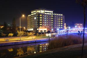 a tall building with a lit up bridge at night at Parion Hotel in Çanakkale