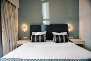 a bedroom with a large bed with two pillows at Rigas Boutique Hotel & Spa in Afitos