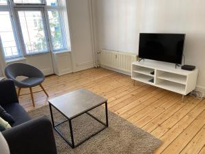 a living room with a flat screen tv on a white cabinet at Koldinggade in Copenhagen